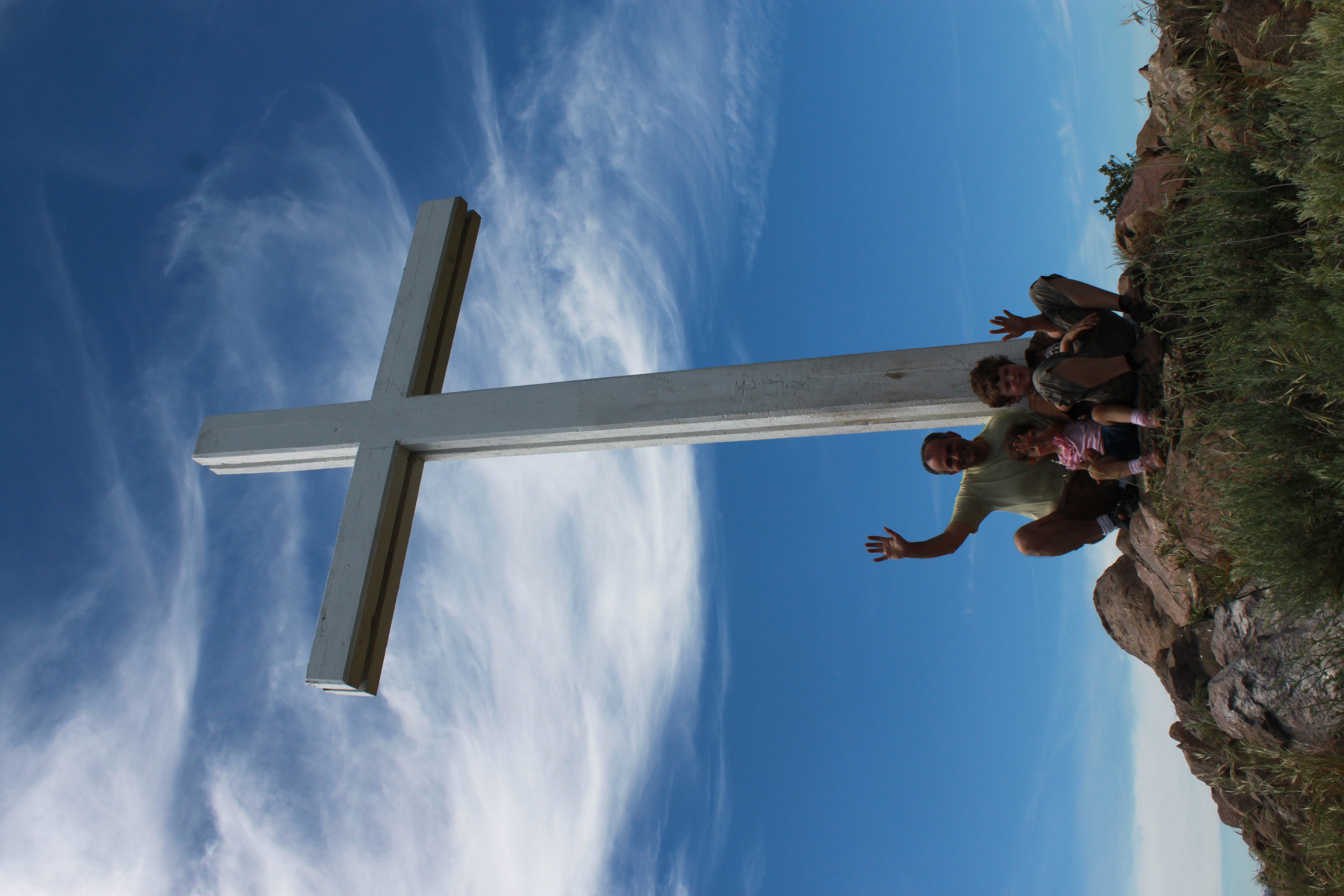Family waving from the base of the white cross